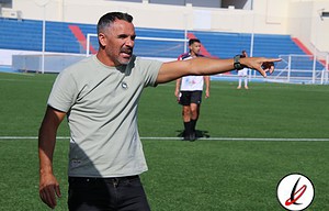 Entrenador señalando en el campo de fútbol durante un entrenamiento.