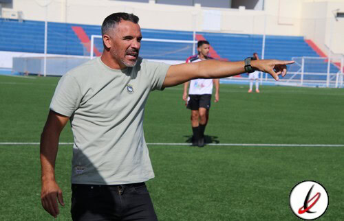 Entrenador señalando en el campo de fútbol durante un entrenamiento.