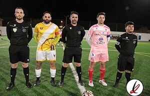 1. Cinco árbitros y dos jugadores en el césped de un campo de fútbol durante una noche de partido.