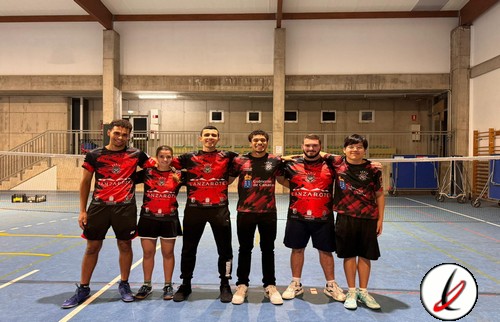 Jugadores de Lanzarote Deportiva en una cancha cubierta, vistiendo camiseta deportiva roja y negra, posando juntos para una foto de equipo en un gimnasio o pabellón deportivo.
