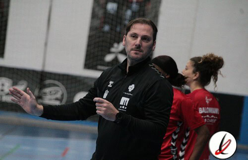 Entrenador de fútbol sala en pista con jugadoras en el fondo, durante un partido o entrenamiento en Navarro Deportes, Lanzarote.