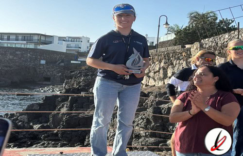 Una mujer con gorra y camiseta oscura sosteniendo un trofeo de vela en Lanzarote Deportivo.