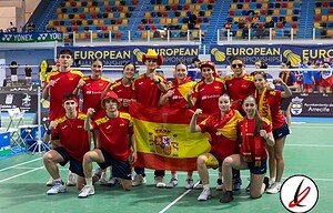 1. Jugadores de bádminton del equipo español celebrando con la bandera en un estadio deportivo durante un campeonato europeo.