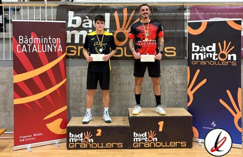 1. Dos jugadores de bádminton en el podio de una competición, uno en primer lugar y otro en segundo, con medallas y certificados, en una instalación deportiva cubierta.