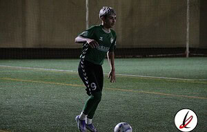Una jugadora en un campo de fútbol, preparándose para chutar el balón durante un entrenamiento indoor en Lanzarote Deportiva.