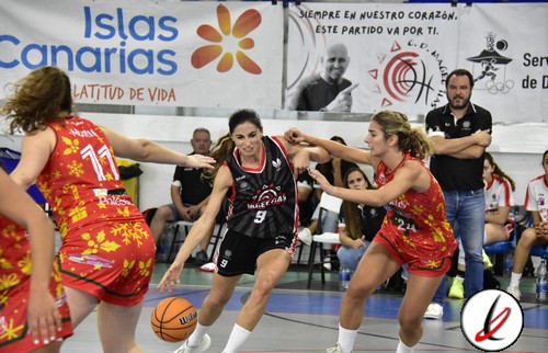 1. Jugadoras de baloncesto en acción durante un partido en una cancha cubierta, con el público y banners publicitarios visibles en el fondo.