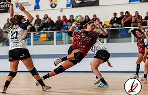 4.ataque de jugadora en un partido de balonmano en un estadio con público en las gradas, jugadoras en acción, enfoque en la portera intentando detener el tiro.