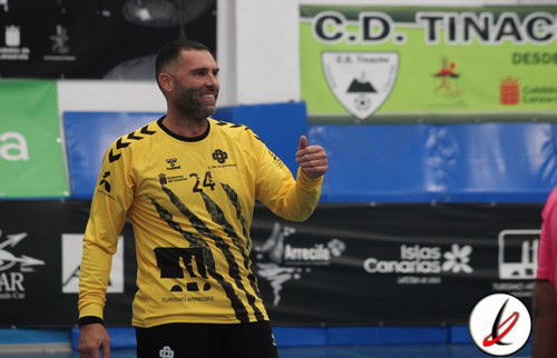 1. Jugador de fútbol celebrando en el campo, viste camiseta amarilla con detalles negros, en un estadio con publicidad y logotipos deportivos de fondo.