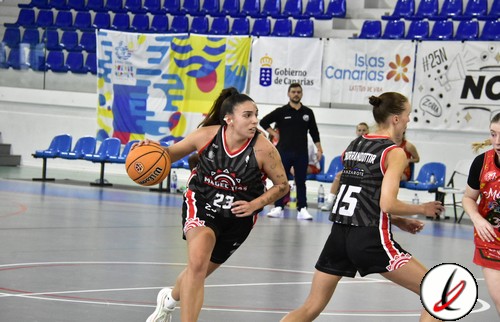 Láser de baloncesto femenino en acción en una cancha cubierta con público y anuncios publicitarios.