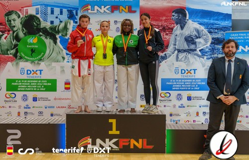 1. Cuatro atletas en podio de judo con medallas, en una ceremonia de premios, acompañados por un juez, en un evento deportivo en Tenerife.