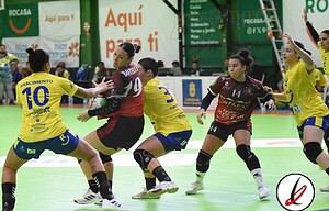 Líderes del partido de balonmano en Lanzarote con jugadoras en acción, algunas en defensa y otras en ataque durante un intenso encuentro en el pabellón deportivo.
