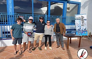 Hombres y mujer posando con trofeo en terraza exterior de Lanzarote Deportiva.