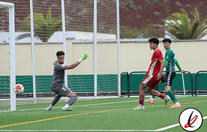 1. Portero en acción deteniendo un disparo durante un partido de fútbol en césped artificial en Lanzarote.