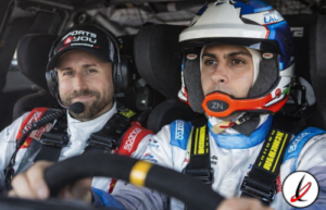1. Pilotos de rally en sus coches, uno con casco y otro con auriculares, preparados para la carrera en un entorno de competición automovilística.