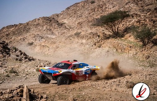 Piloto de rally raid conduciendo un coche en terreno árido y montañoso, levantando polvo mientras compite en una carrera por Lanzarote.