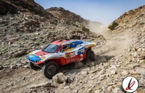 1. Vehículo de rally todo terreno en un camino rocoso y árido en Lanzarote, con montañas y polvo en el aire.