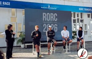 Cabo de entrevista con cuatro personas en panel de discusión en evento deportivo RORC Transatlántic Race 2026 en Lanzarote, con pantalla grande y logotipo en fondo, en exteriores.