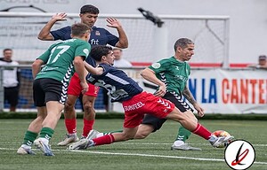 1. Jugadores de fútbol en acción durante un partido en el campo de Lanzarote Deportiva, con jugadores en camiseta verde y azul, en un ambiente de competición en el estadio.