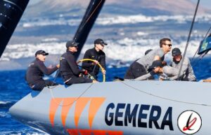 Equipo de regatistas navegando en un velero con el logo GEMERA en el mar durante una competición.