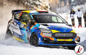 Coche de rally en nieve, piloto en acción en un entorno invernal con espectadores en el fondo.
