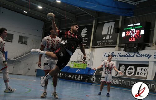 Jugador de balonmano en acción lanzando el balón en un partido en un pabellón cubierto.