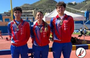 Tres atletas con medallas en un evento deportivo en un estadio al aire libre en Lanzarote.