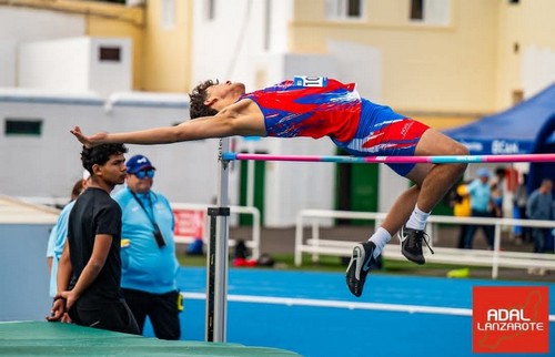 Salto de atleta en la prueba de salto con pértiga en un estadio al aire libre.