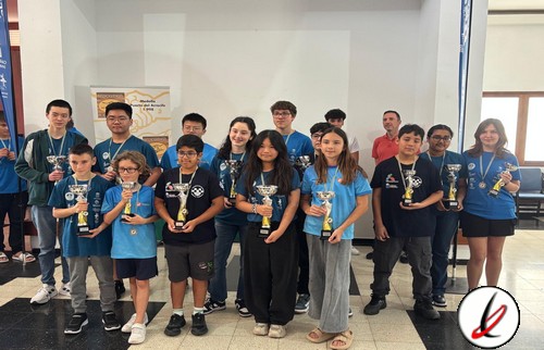 Campeones de un torneo escolar con medallas y trofeos, grupo de niños y jóvenes en un evento deportivo en un espacio interior.