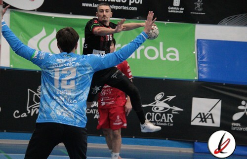 Jugador de balonmano en acción, lanzando el balón mientras es defendido por un portero en un partido en Lanzarote.