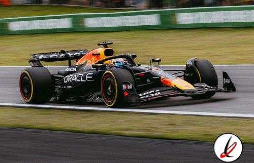 Red Bull Racing RB19 de Fórmula 1 en pista, coche de carreras en movimiento en un circuito, con patrocinadores y diseño aerodinámico, en un día de carrera.