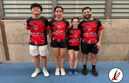 Cuatro jóvenes deportistas con camisetas rojas y negras en un gimnasio, posando juntos para la foto.