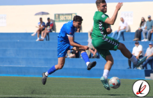 Línea 1: Jugadores de fútbol en acción durante un partido en un campo al aire libre con espectadores en las gradas.