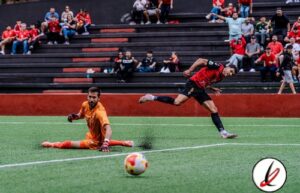 1. Jugadores de fútbol en acción durante un partido en el estadio, con espectadores en las gradas, en Lanzarote Deportiva.
