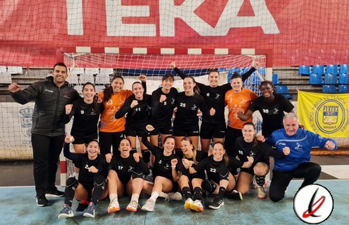 Jugadoras de fútbol sala en un equipo femenino, posando en la pista de un estadio con un arco y red de fondo.