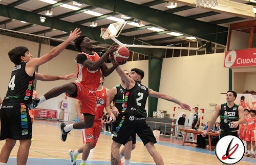 Jugadores de baloncesto en acción durante un partido en un gimnasio cubierto.