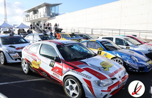 Coches de carreras en la parrilla de salida en un circuito de Lanzarote, con varios vehículos deportivos preparados para una competición.