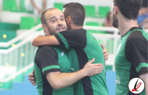 Jugadores de fútbol en celebración en el campo, con gradas verdes en el fondo.