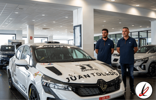 Dos hombres de pie junto a un coche de carreras en un concesionario de automóviles, en un entorno moderno y bien iluminado.
