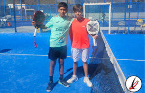 Dos jóvenes jugadores de pádel en una pista azul, con raquetas en mano, posando juntos después de un partido en Lanzarote.