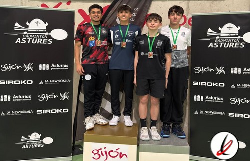 Cuatro jóvenes deportistas en el podio de un torneo de bádminton en Astures, con medallas y camisetas deportivas, en un evento en Gijón.