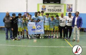 Jugadores de baloncesto en una cancha cubierta, posando con trofeo y diploma tras un partido o torneo escolar.