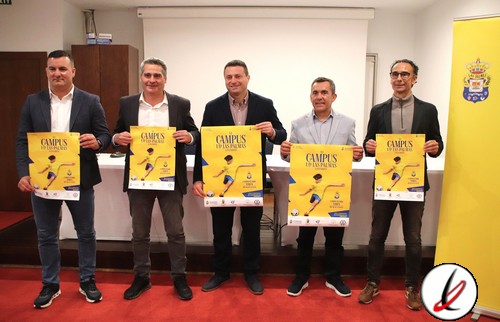 Cinco hombres de pie en una sala, sosteniendo carteles promocionales de un evento deportivo en Lanzarote.