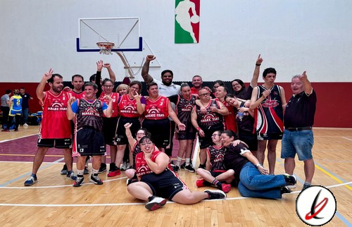 Equipo de baloncesto celebrando en la cancha con jugadores, entrenador y público, en un ambiente de victoria y alegría.