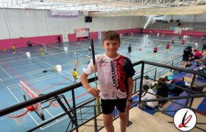 Niño con raqueta de bádminton en una pista cubierta, en un evento deportivo juvenil en Lanzarote.