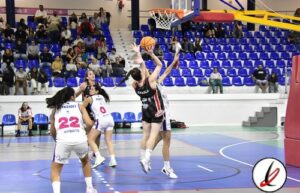 Jugadoras de baloncesto en acción durante un partido en una cancha cubierta.