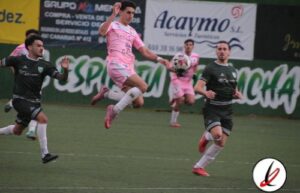Jugadores en acción durante un partido de fútbol en un estadio, con uno en el aire intentando controlar el balón, mientras otros lo persiguen en el campo.