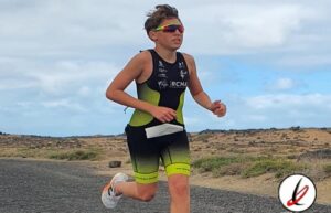 Correr niño en un paisaje árido, usando ropa deportiva y gafas de sol, durante una competencia de atletismo en Lanzarote.